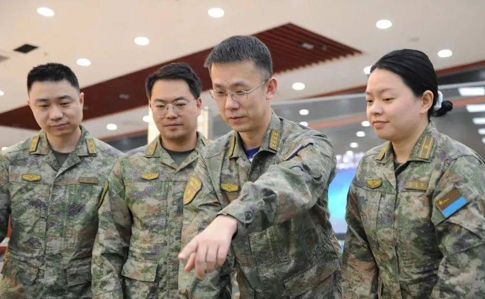 他是国防大学教授，他的办公桌上摆放着三个电脑显示屏……